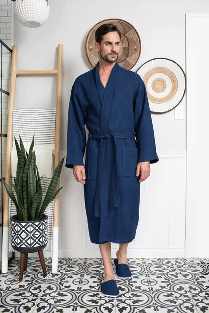 Man wearing a blue robe standing in a room with decorative elements.