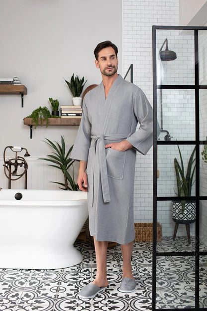 Man wearing a gray bathrobe in a bathroom setting