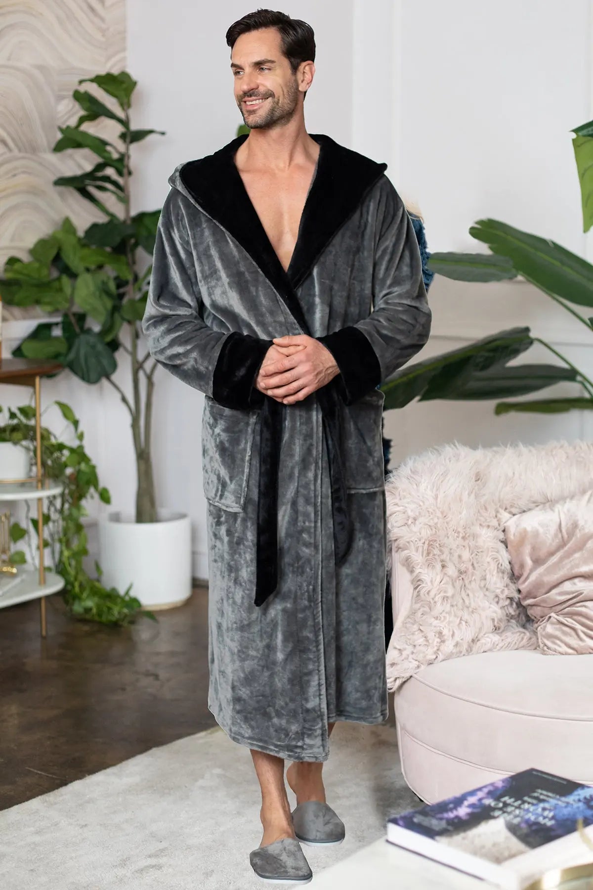 Man wearing a gray robe with black trim in a living room setting
