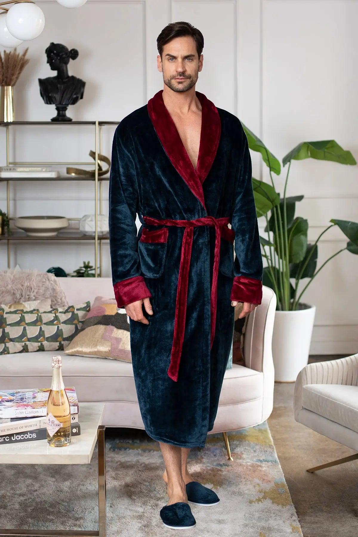 Man wearing a dark blue robe with red trim in a living room setting.
