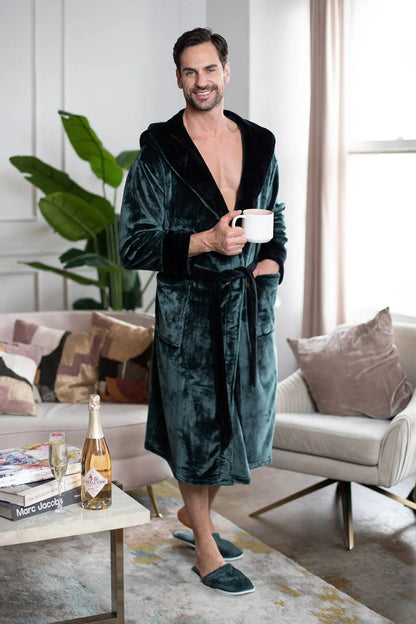 Man in a green velvet robe holding a mug in a living room.